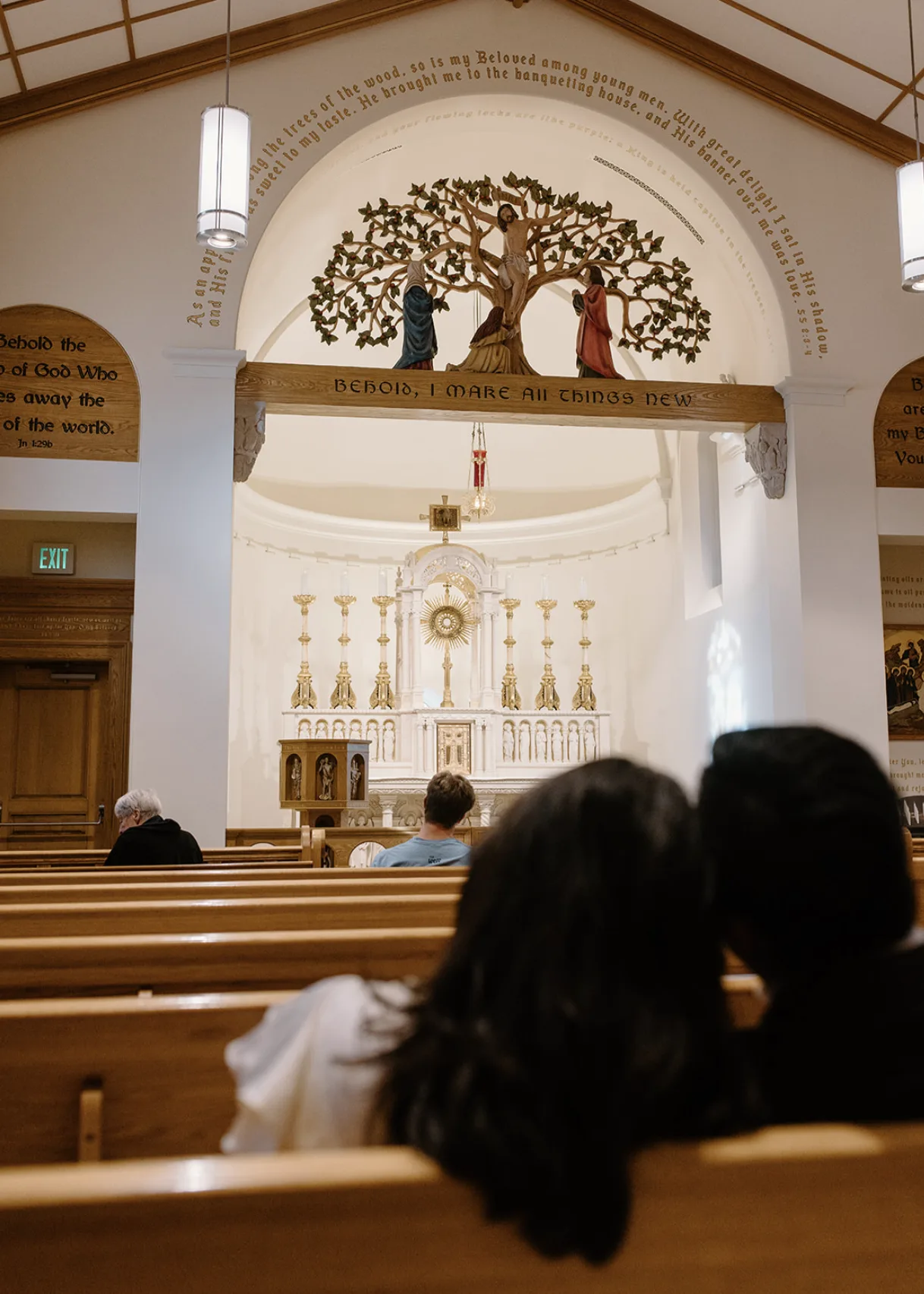 The couple sitting together in the church pews facing the altar