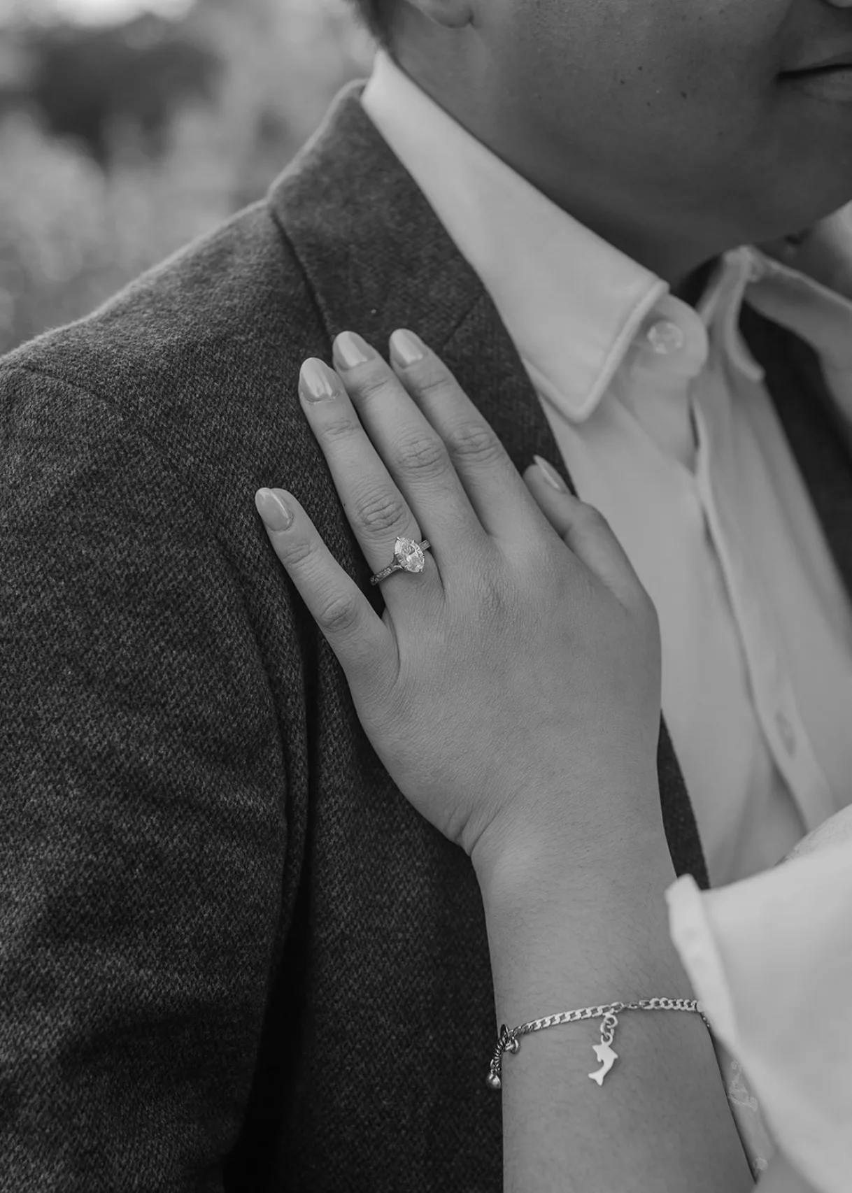 Black-and-white close-up of her ring hand on his lapel