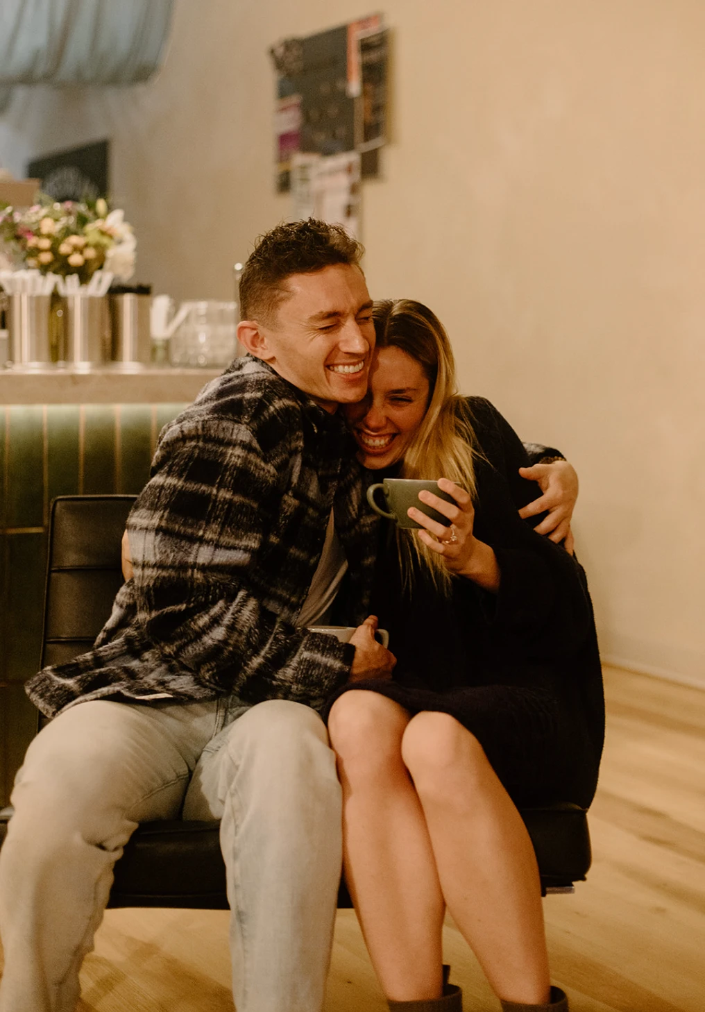 Gerrin and Meredith squeezed into one chair at the café, laughing with coffee in hand