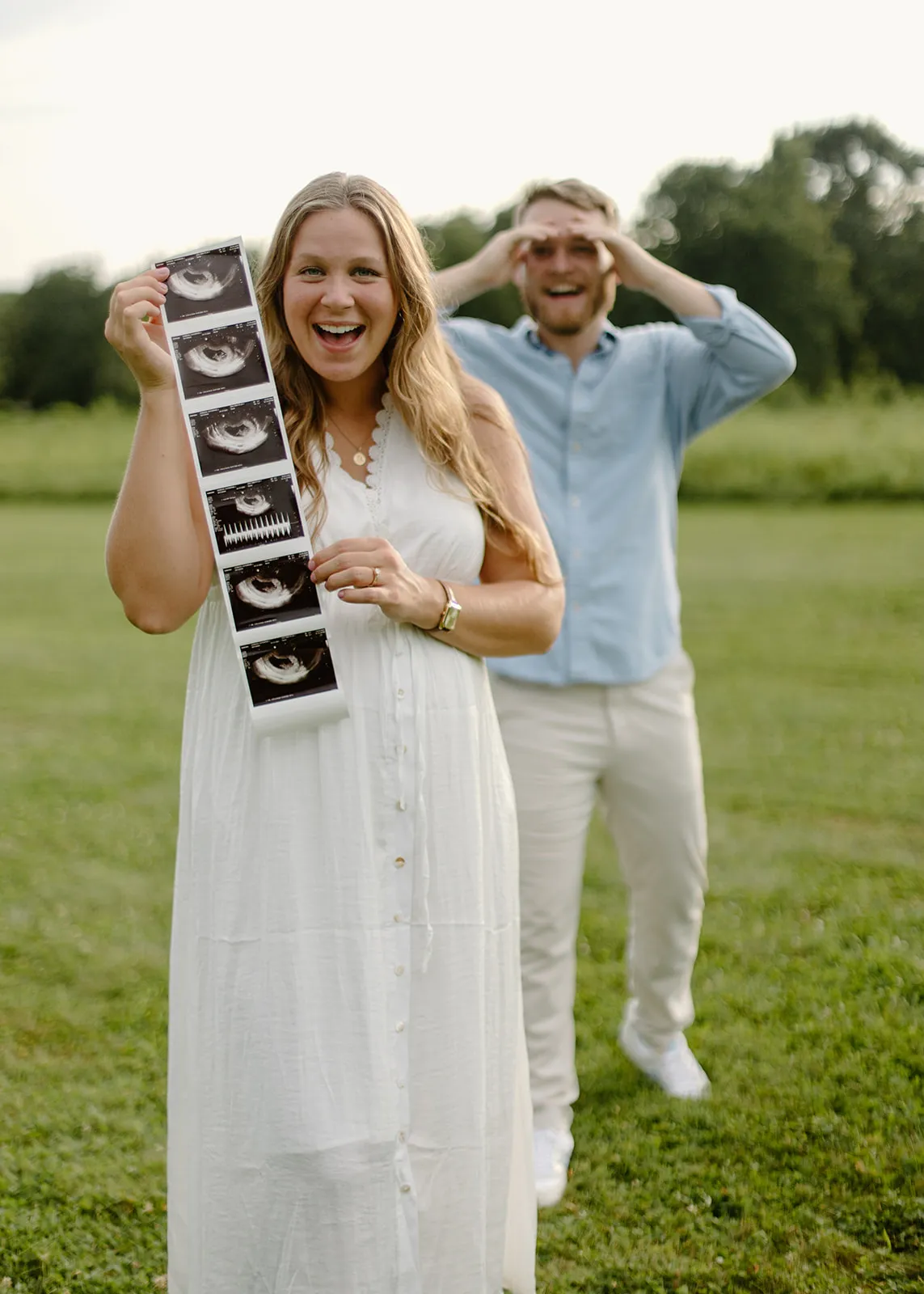 Her holding up the ultrasound strip as he pretends to look through binoculars